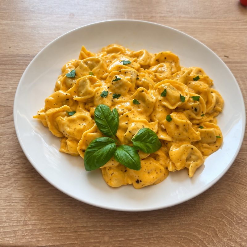 Húsos tortellini cheddar sajtmártással és reszelt sajttal